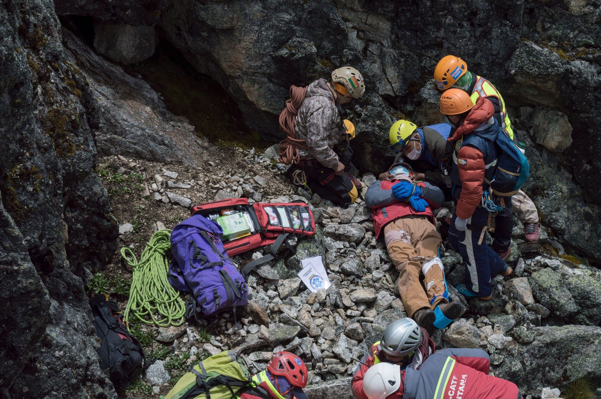A rescue team treating a casualty on rocky ground