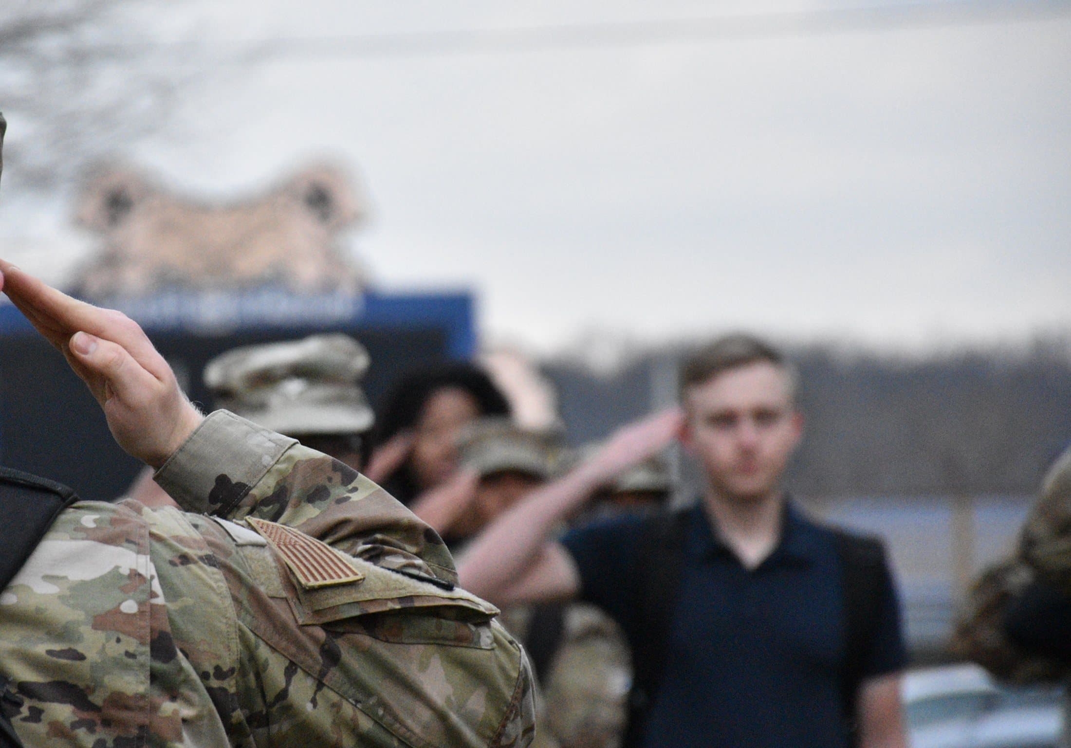 A raised salute at a formation, others saluting behind