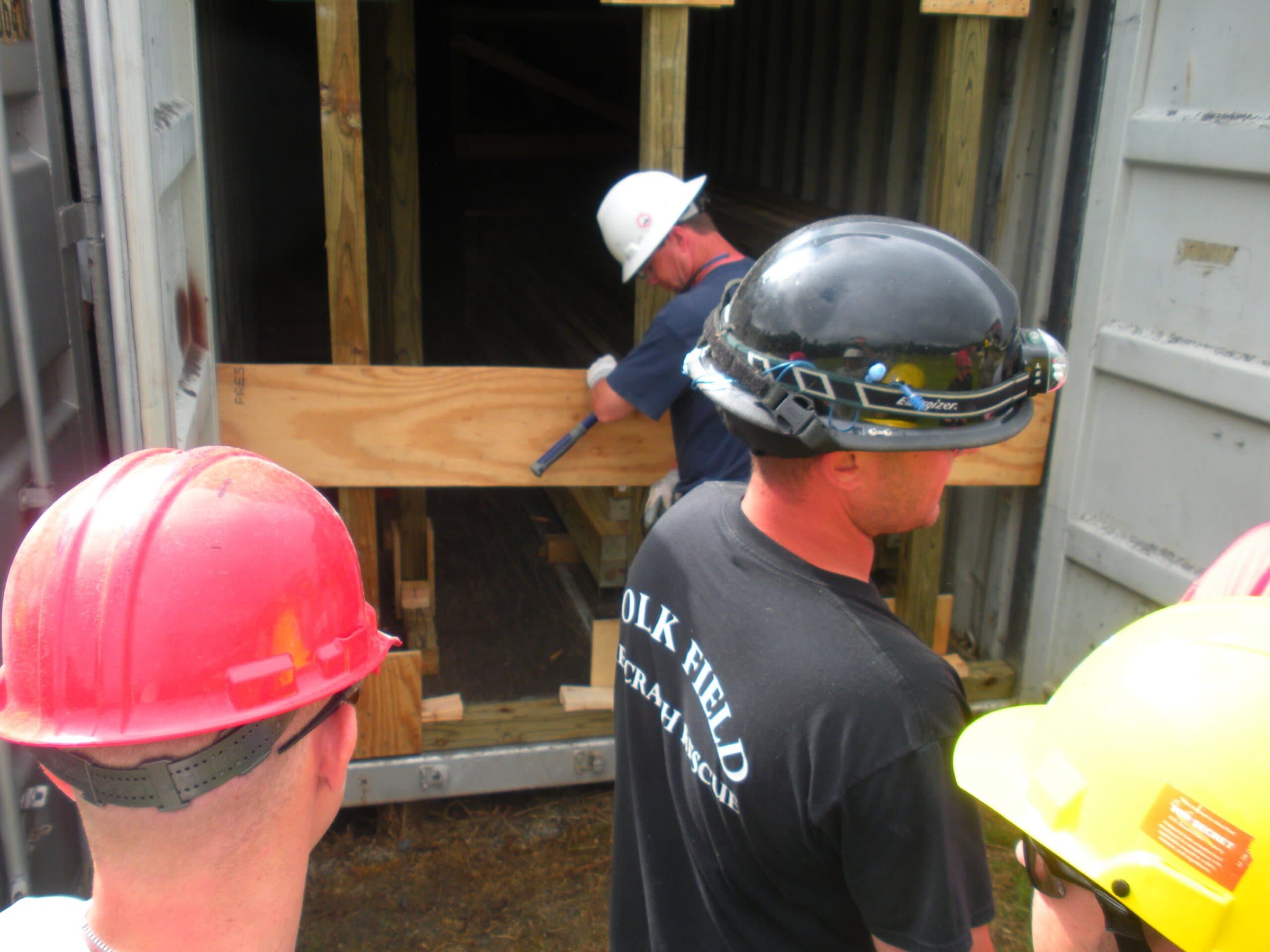 Trainees in hard hats building timber shoring during rescue training